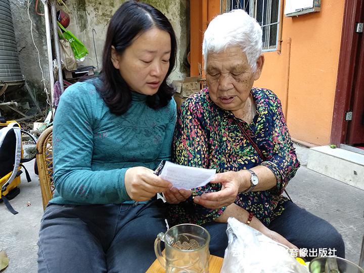 苏玉兰奶奶在向伍琼华老师讲述老照片的故事.jpg